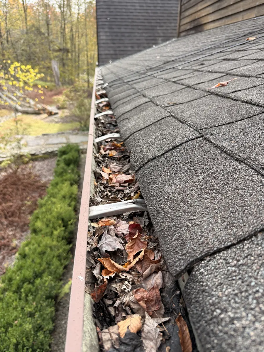 Gutter filled with leaves and debris before AidPro gutter cleaning