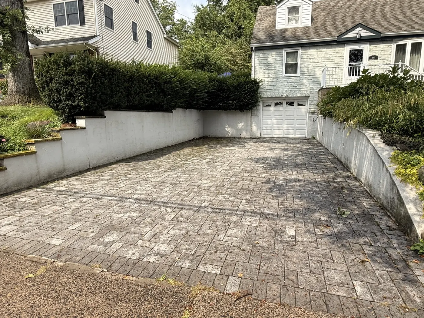 Stained and weathered paver driveway before AidPro cleaning and sealing